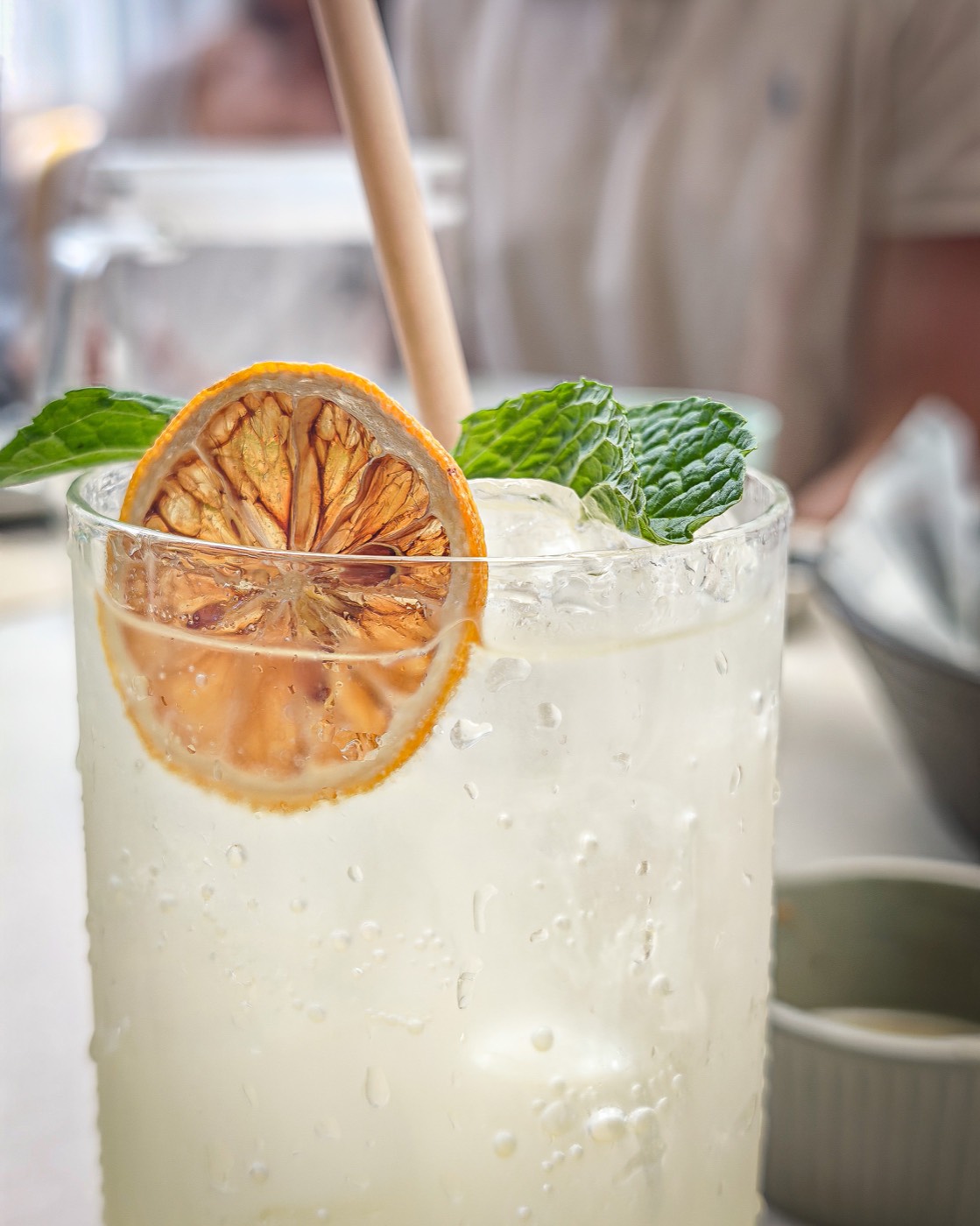 Limonade glacée dans un grand verre, tranche d'agrume séché et feuilles de menthe