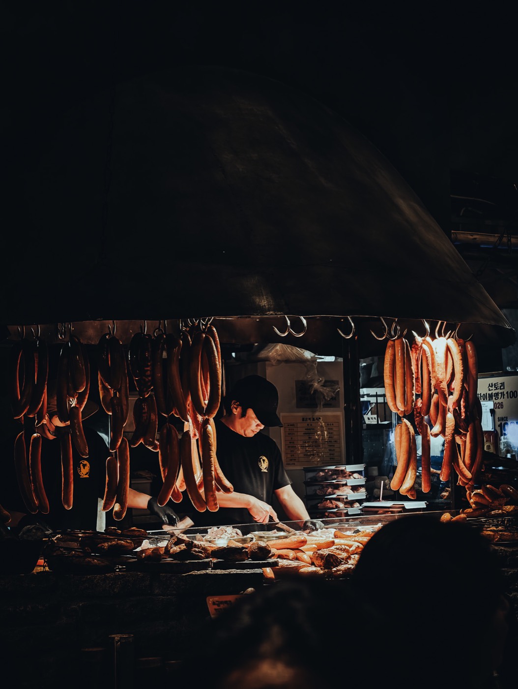 Étal de saucisses grillées sur un marché de nuit